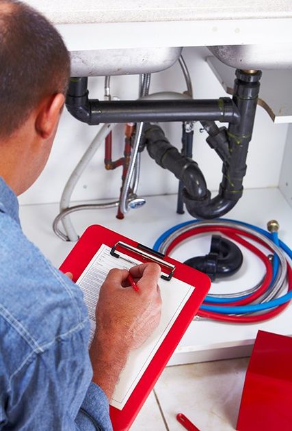 Plumber inspecting pipes