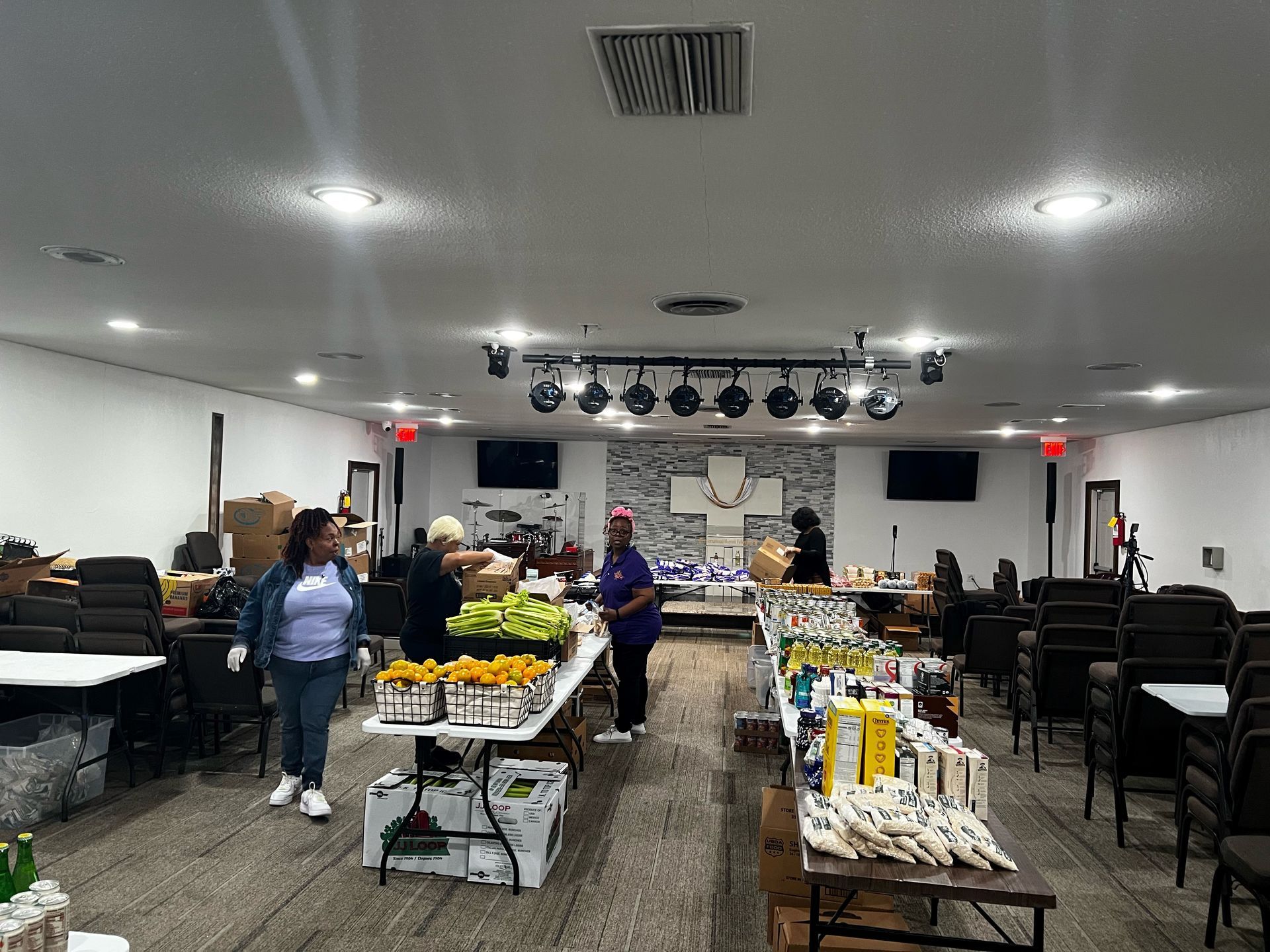 A group of people are standing around tables in a large room. - Lancaster, TX - International Harvest Fellowship Ministries