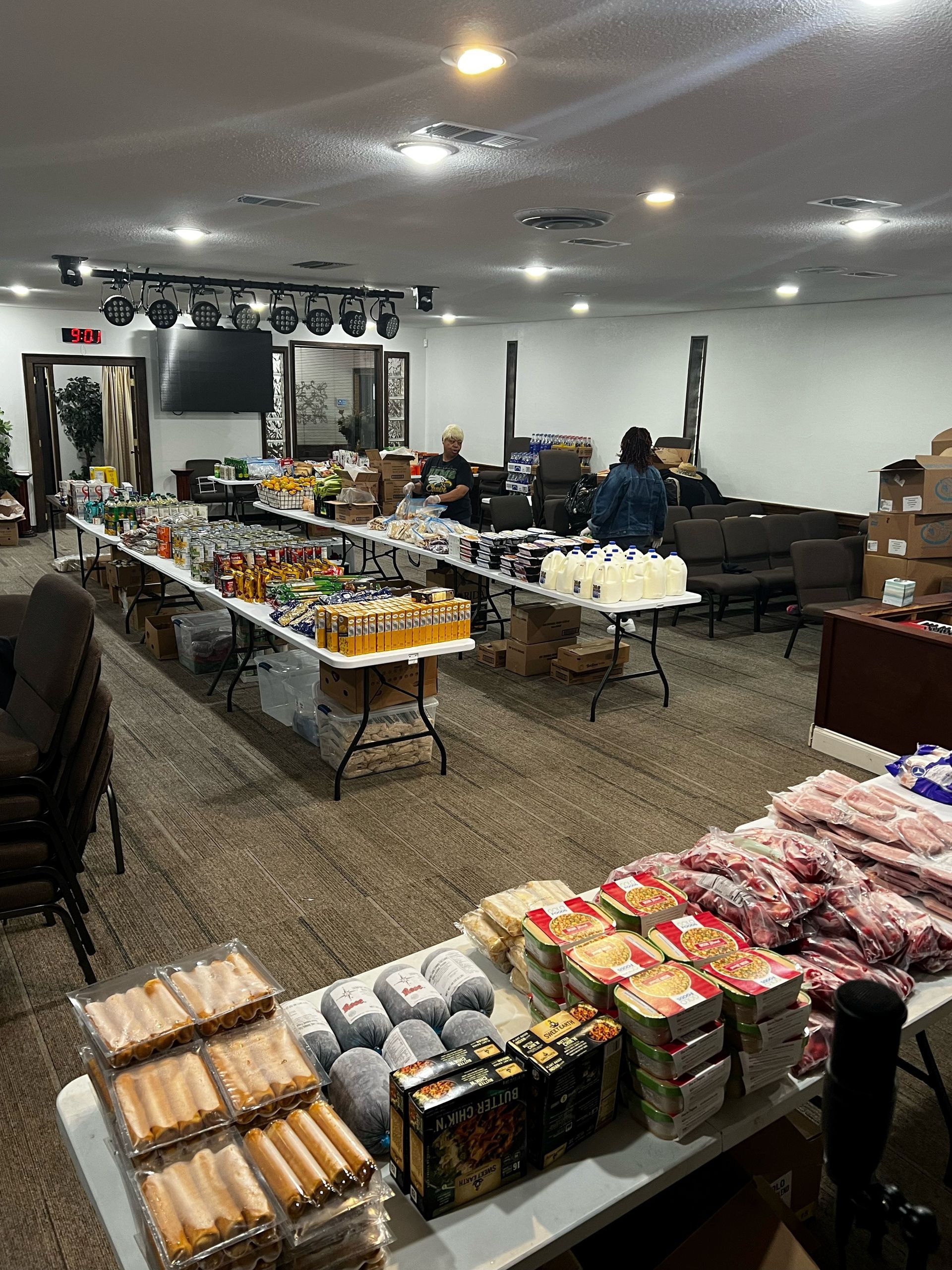 A large room filled with tables and boxes of food. - Lancaster, TX - International Harvest Fellowship Ministries