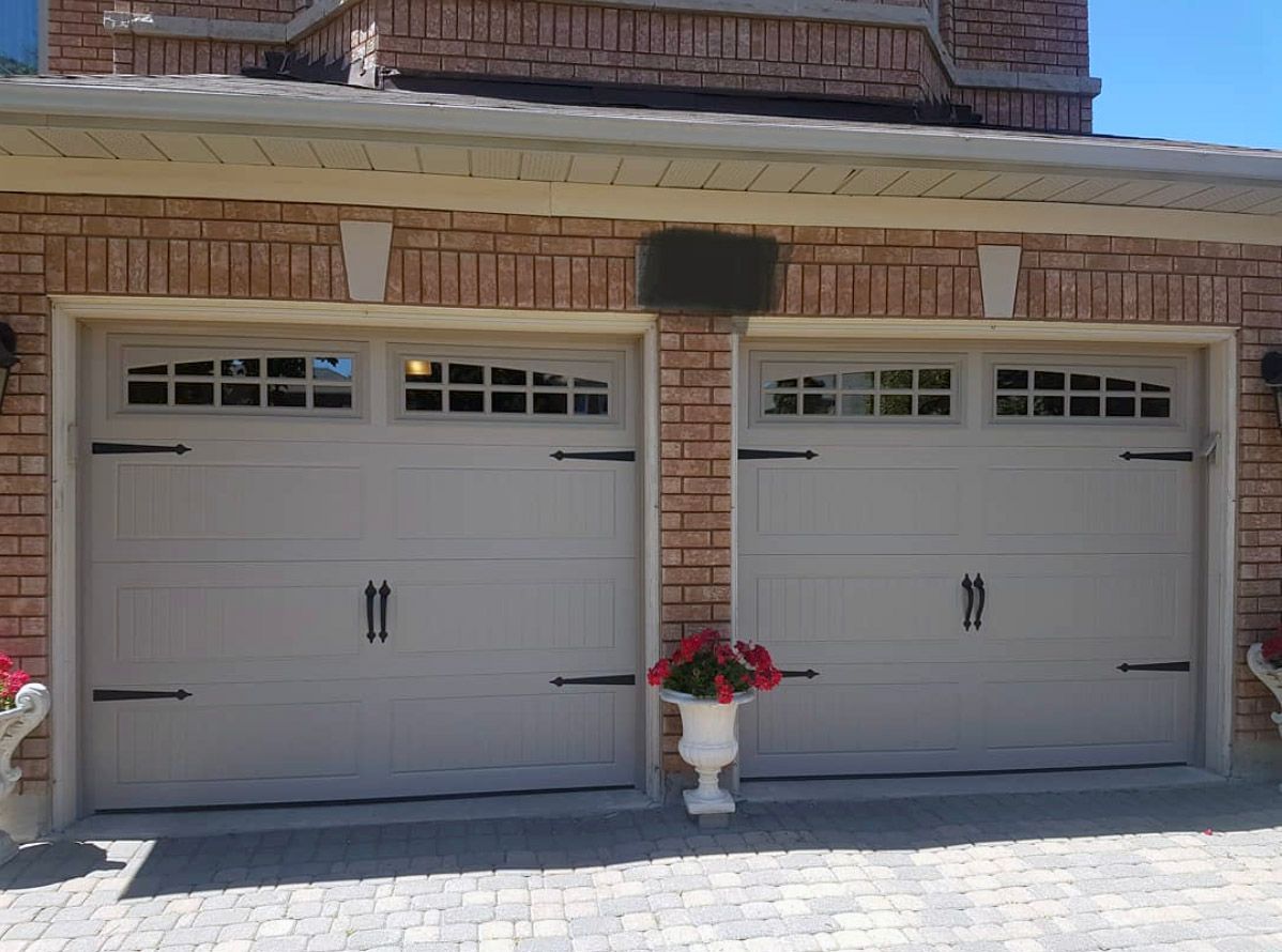 A couple of garage doors with a vase of flowers in front of them