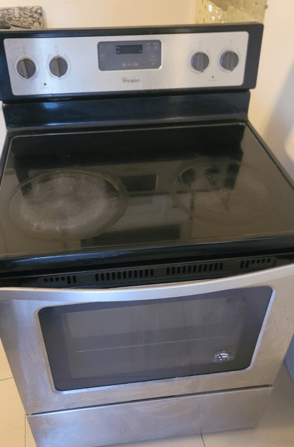 Stainless steel Whirlpool electric range with black cooktop, oven door, and control panel.