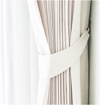 Beige curtain held back by matching fabric tie.