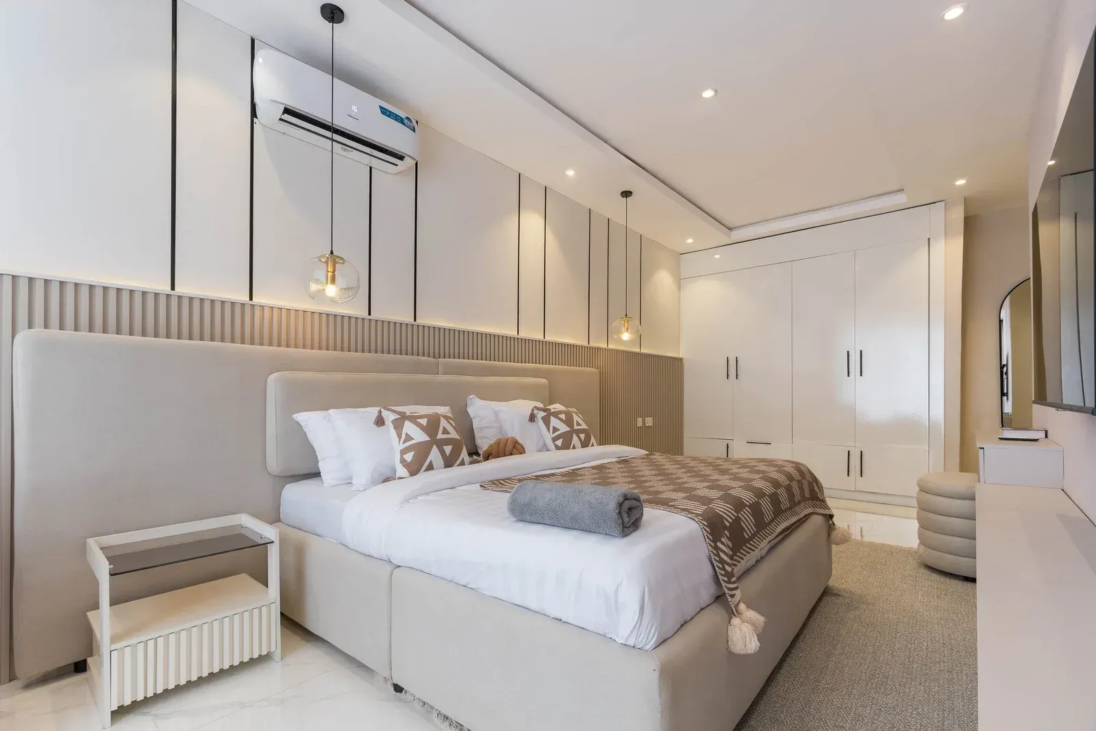 Modern bedroom with a large bed, neutral tones, and en-suite bathroom.