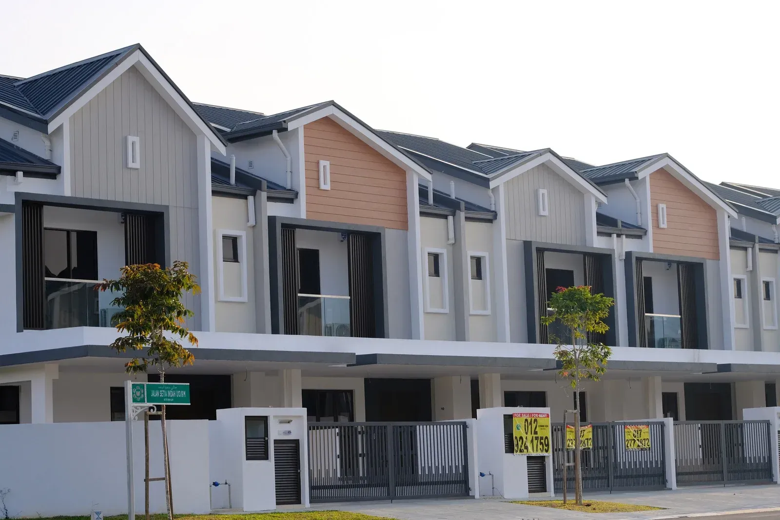 Row of newly built townhouses with light gray and brick accents.