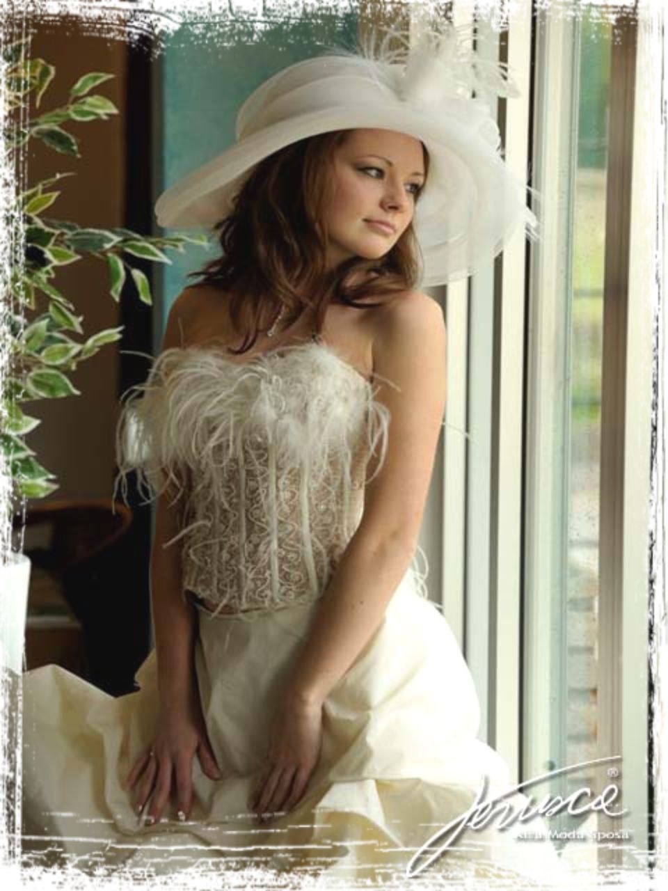 abito da sposa con piume sul corpetto e cappello