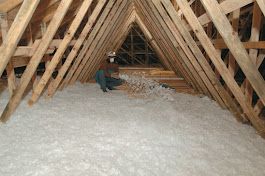 Attic skylight construction with yellow insulation between metal framing.
