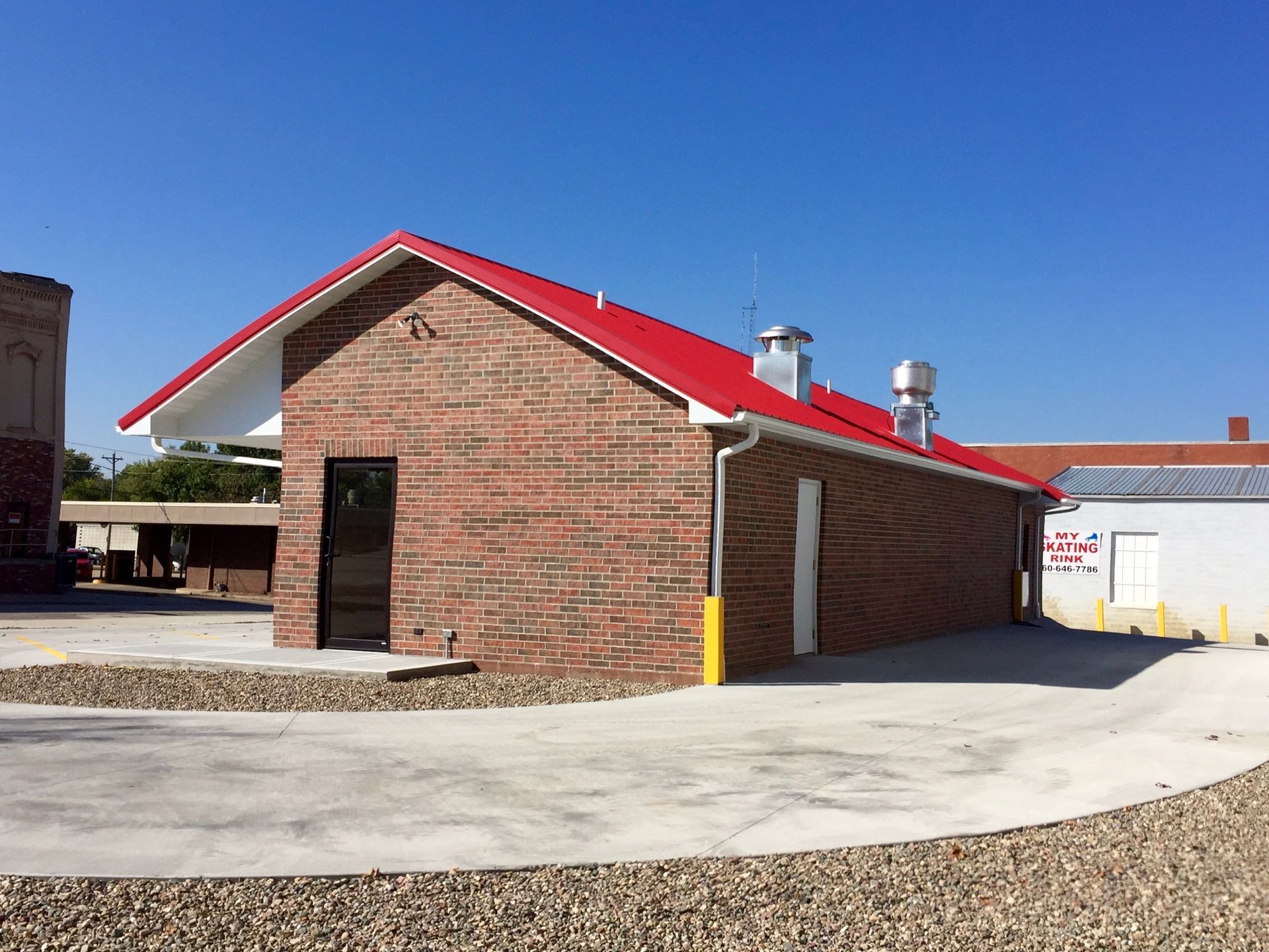 A small brick building with a red roof
