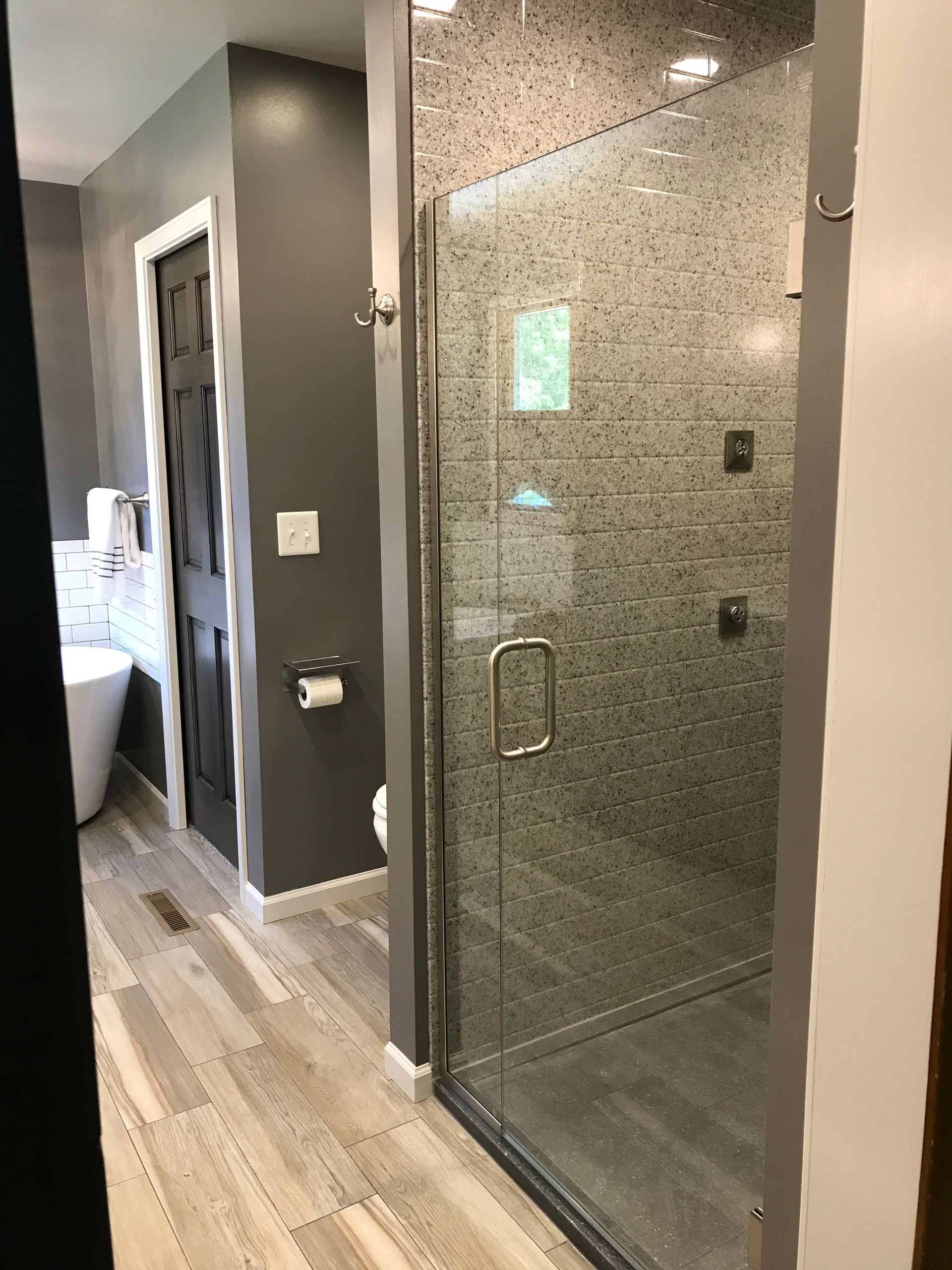 A bathroom with a walk in shower and a tub.