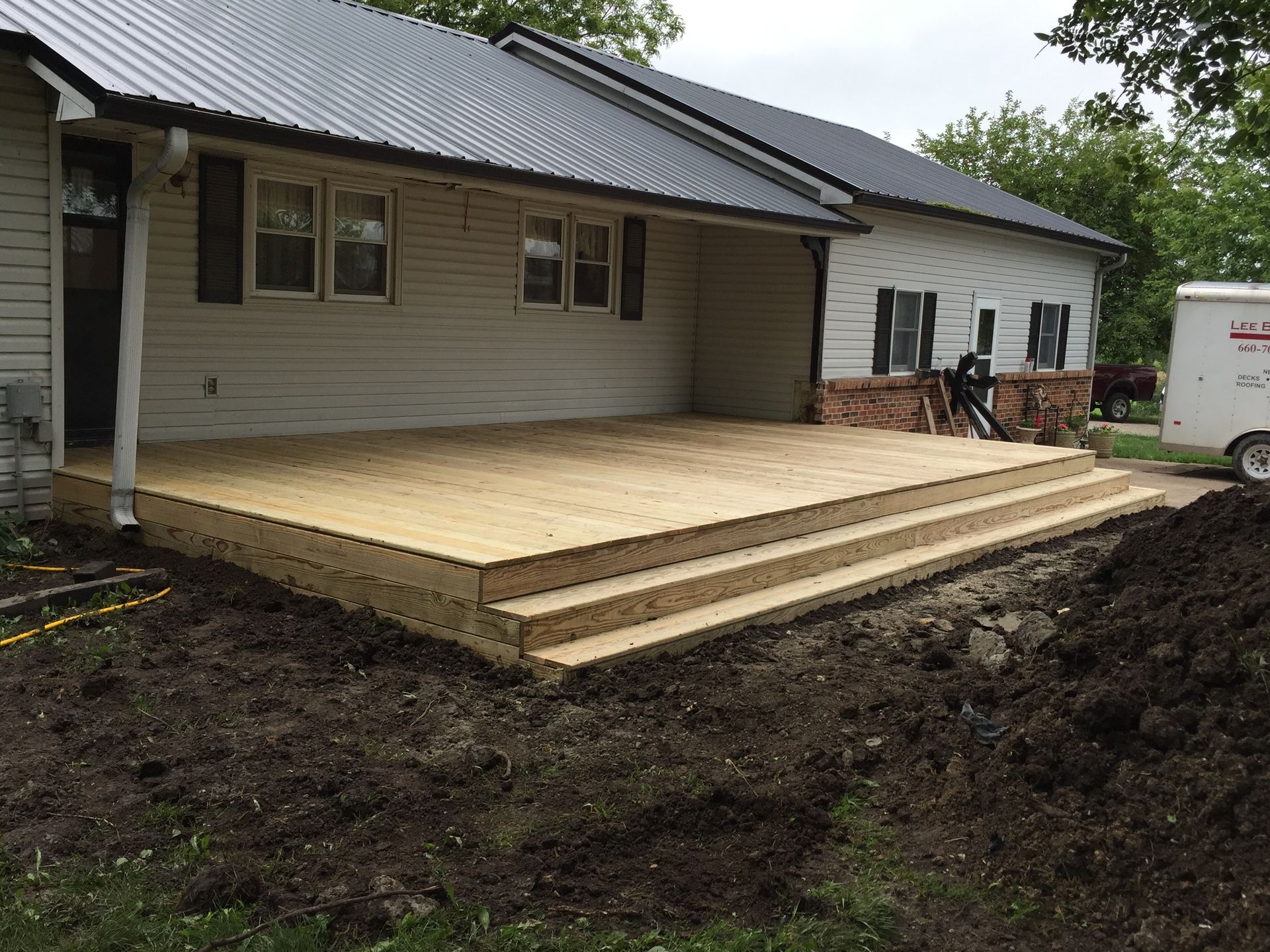 A wooden deck is being built in front of a house.