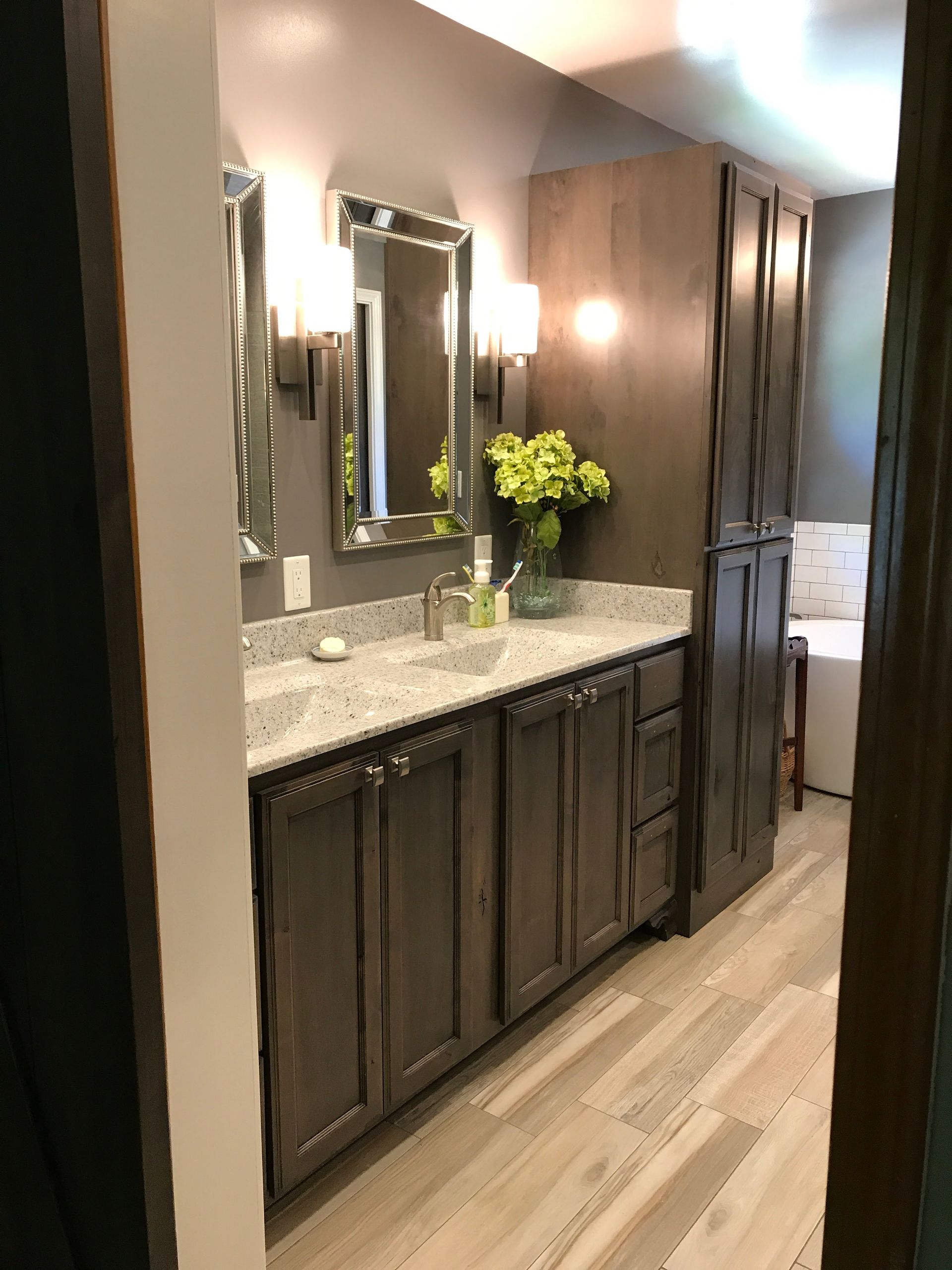 A bathroom with two sinks , a mirror and a tub.