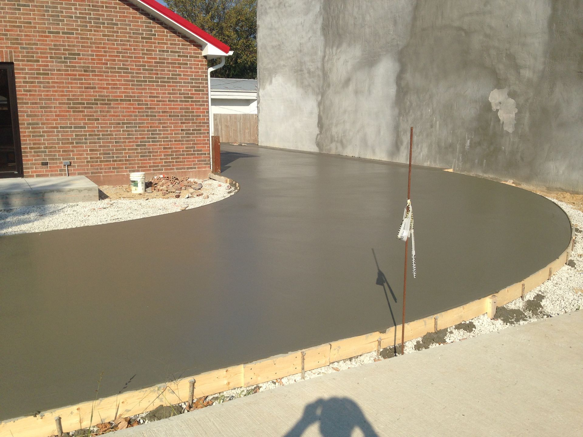 A brick building with a concrete driveway in front of it