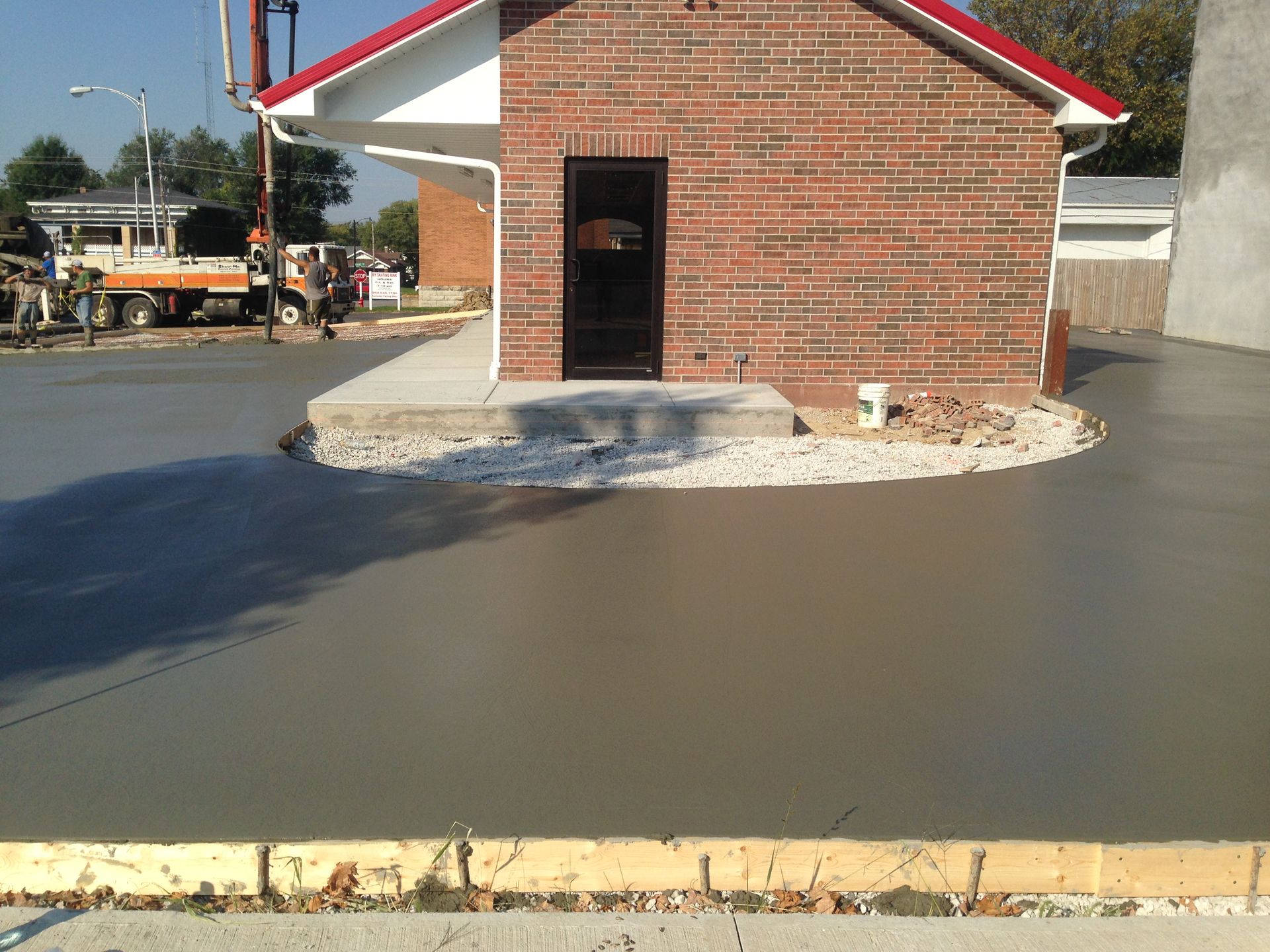 A brick building with a red roof is being built