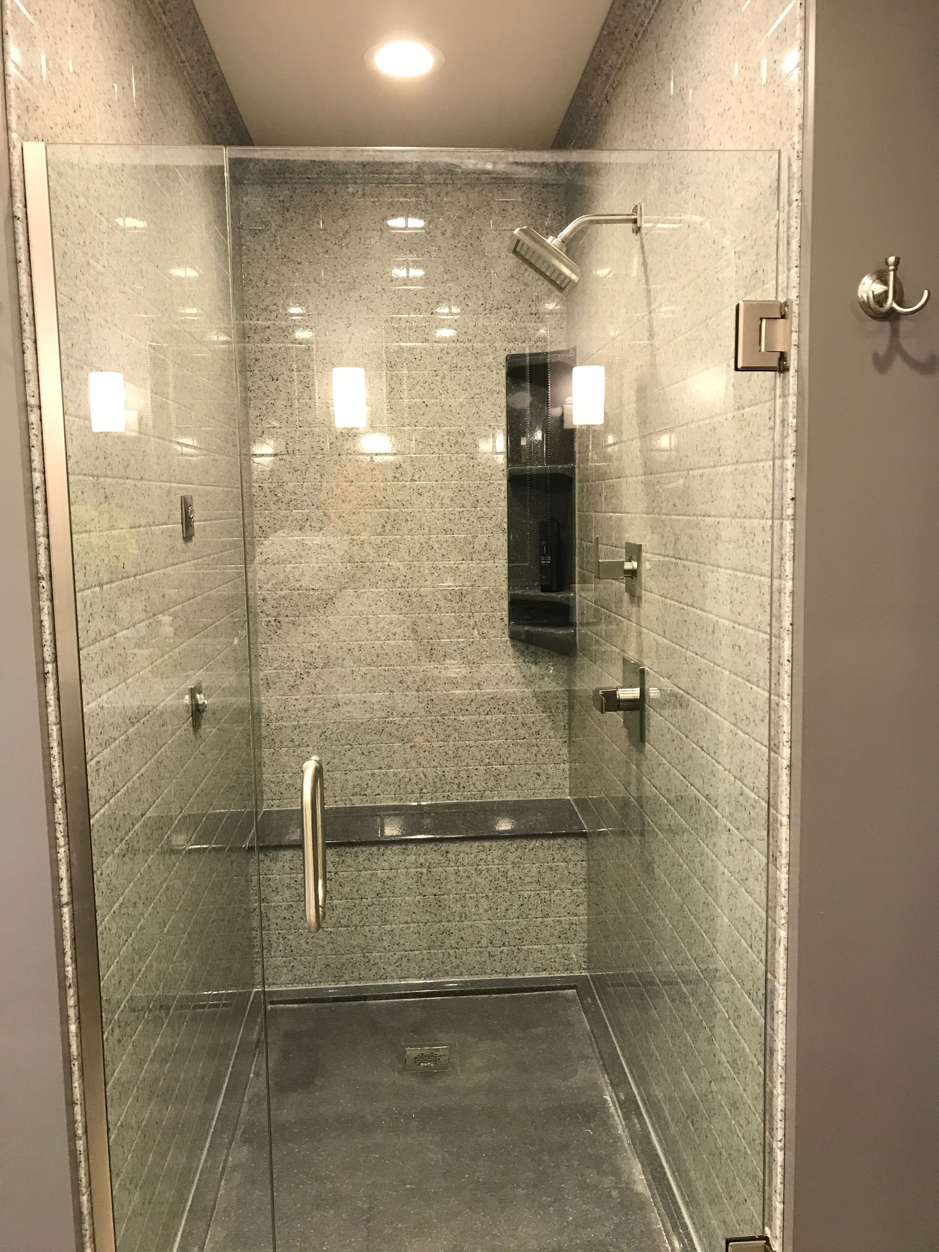 A shower with a glass door and a shower head