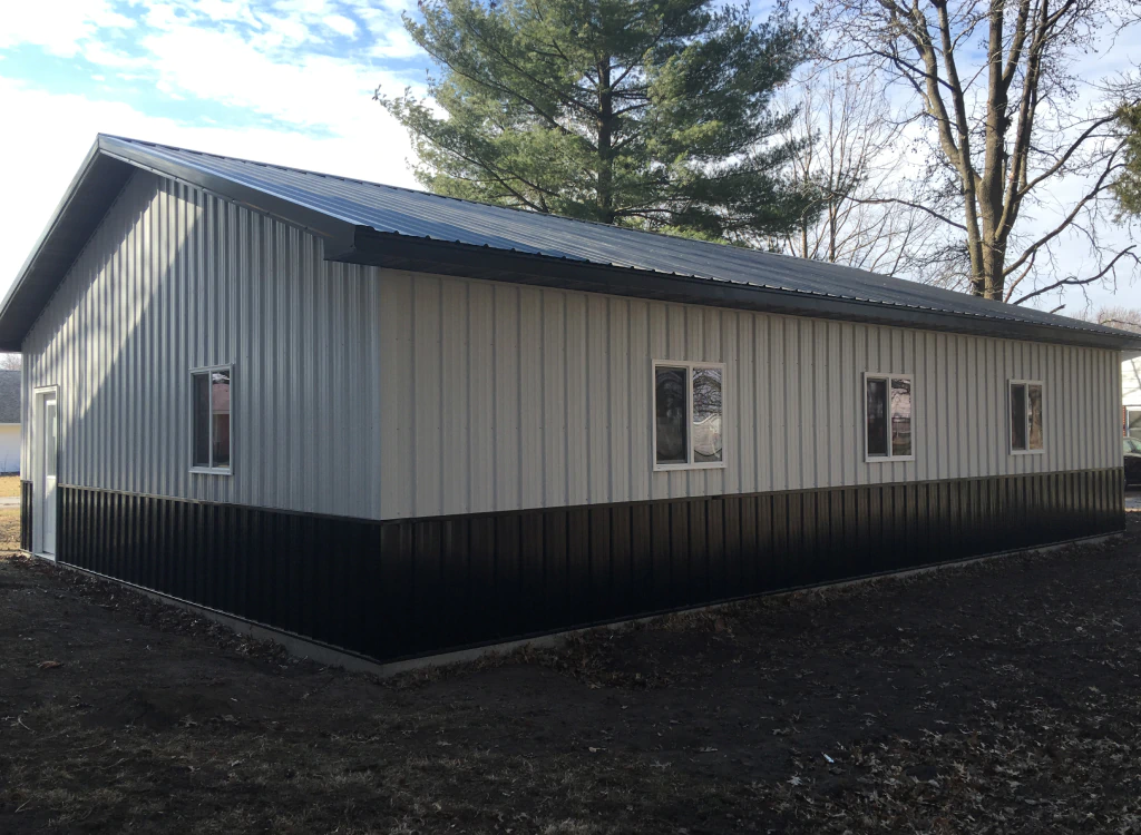 A white and brown building with a black roof and windows