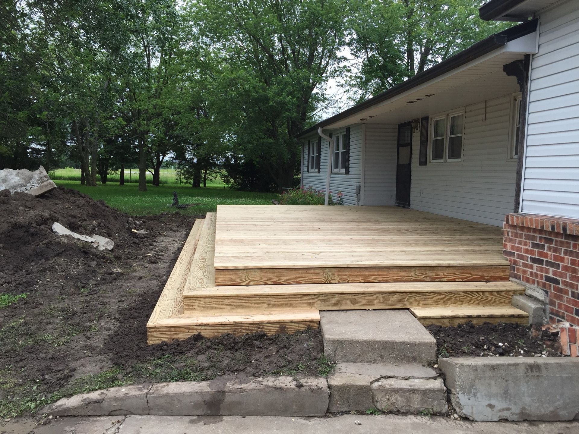 A white house with a wooden deck in front of it