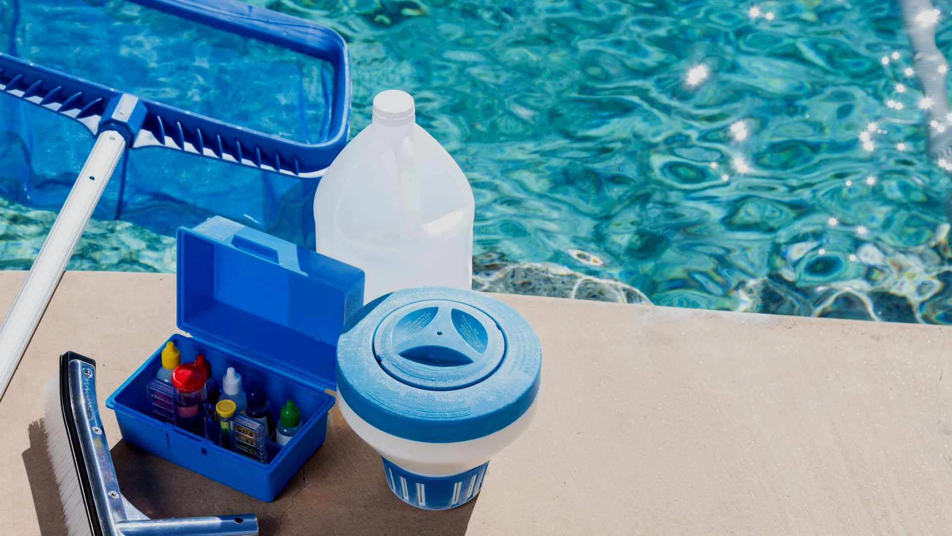 A swimming pool filled with water and cleaning supplies.