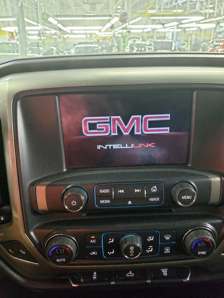 The dashboard of a gmc truck with a gmc logo on the screen.