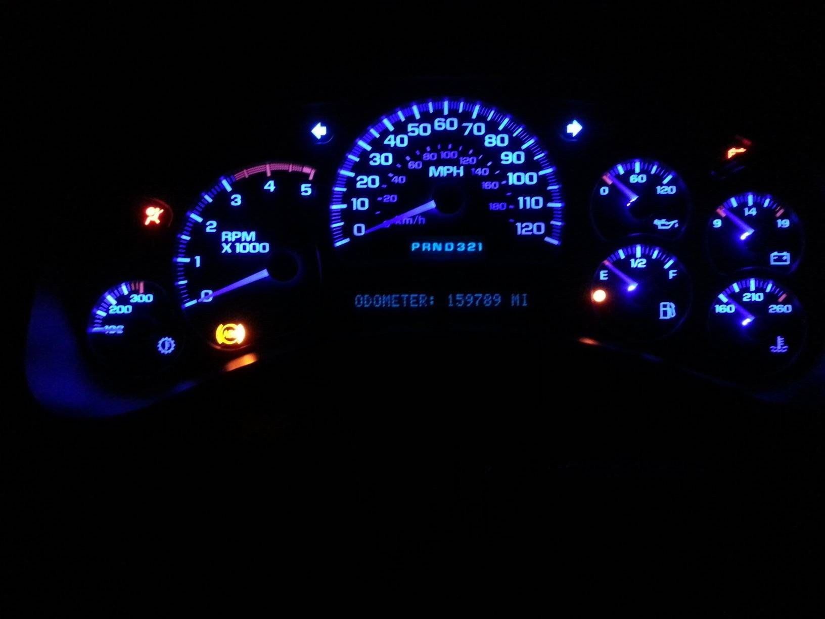 The dashboard of a car is lit up with blue lights