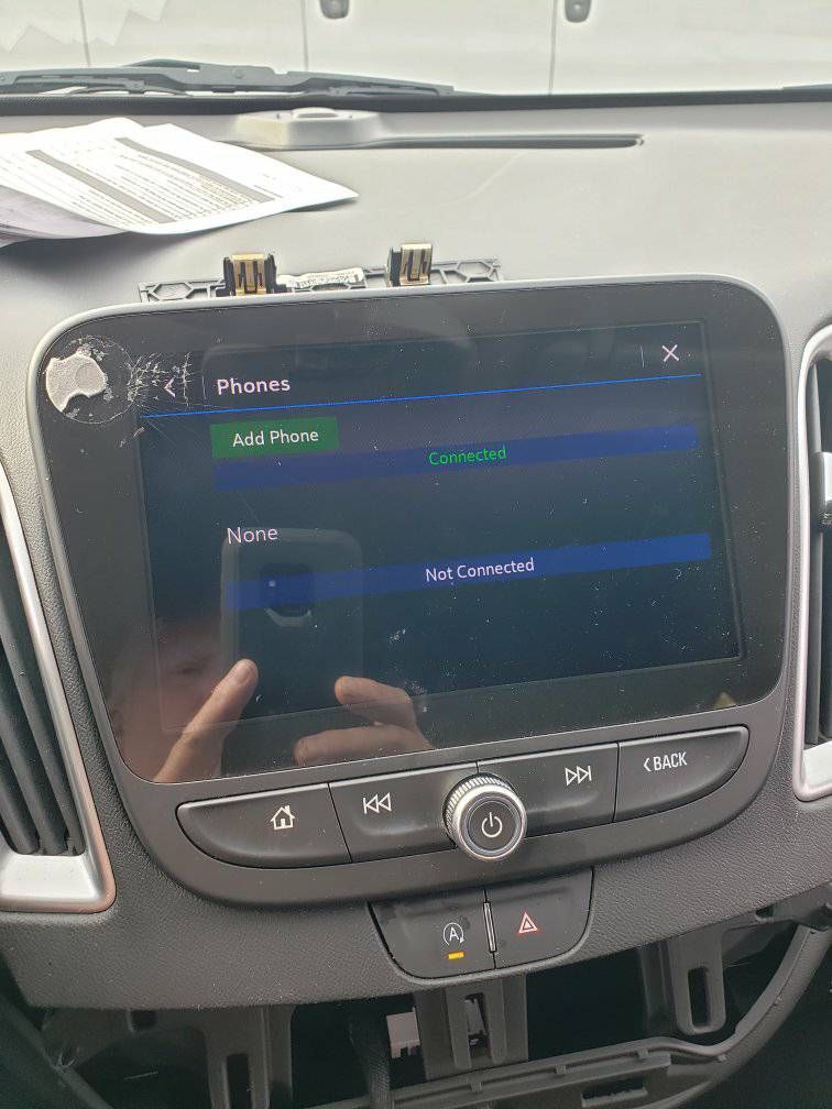 A car radio is sitting on the dashboard of a car.