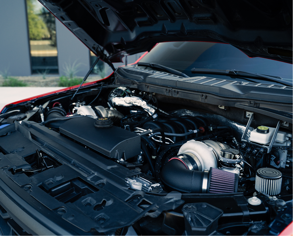 Red pickup truck engine bay with open hood | Dyno-Comp