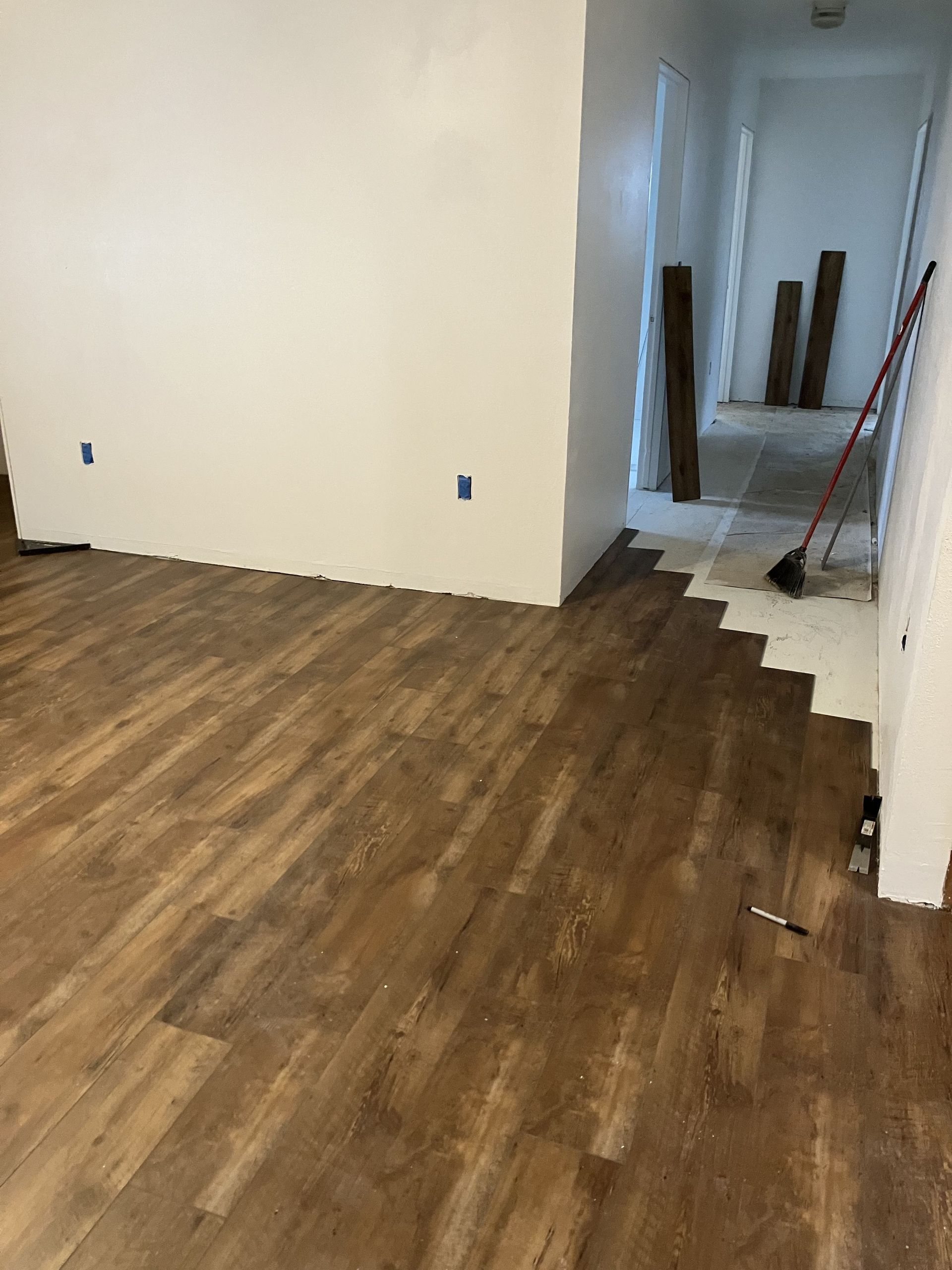 Person wearing gloves tiling a wall with hexagonal tiles using mortar.