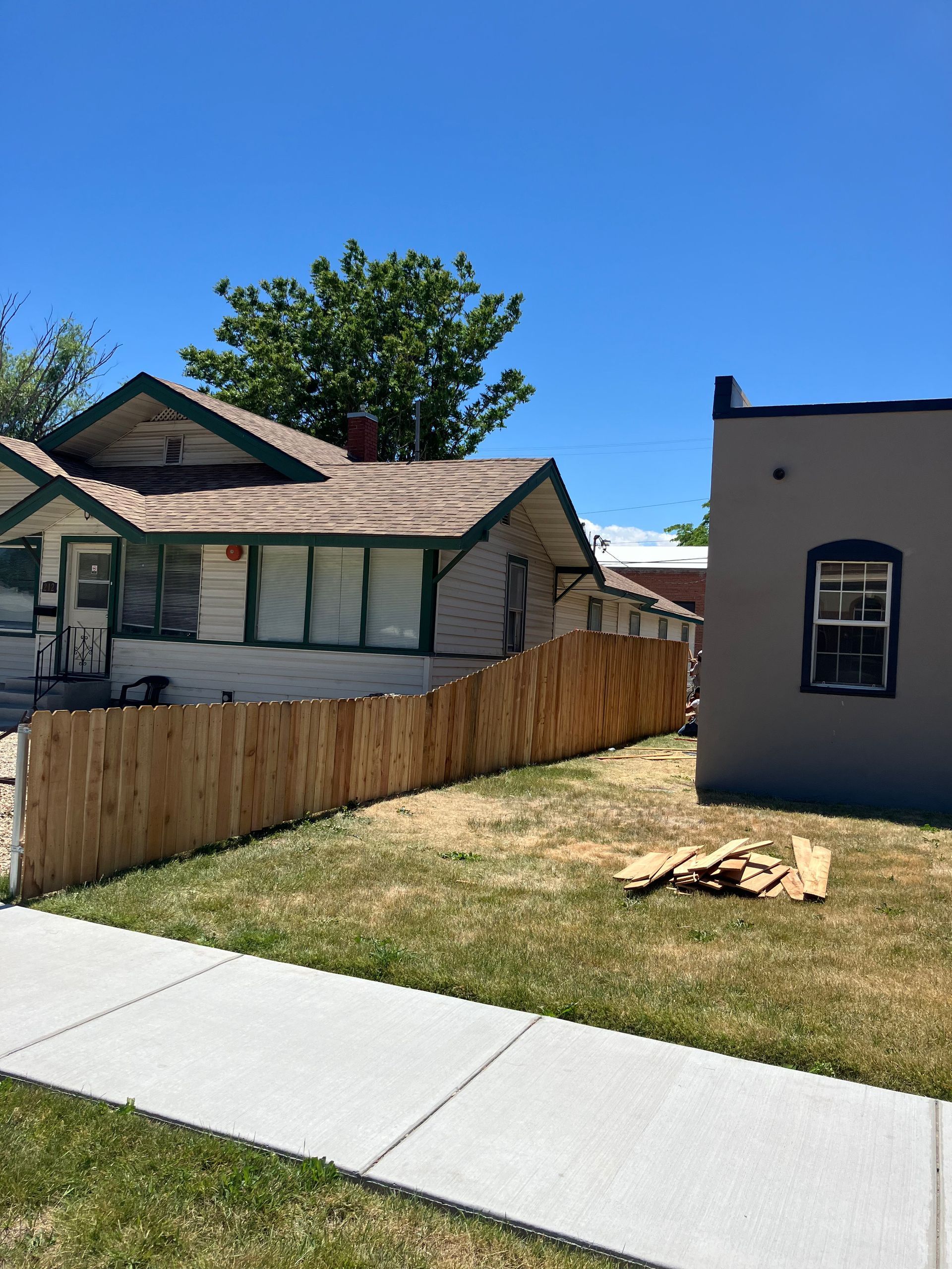 Person wearing gloves tiling a wall with hexagonal tiles using mortar.
