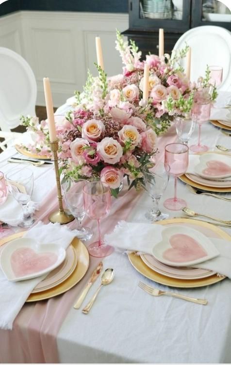 Elegant table setting with pink flowers, gold accents, and heart-shaped plates.