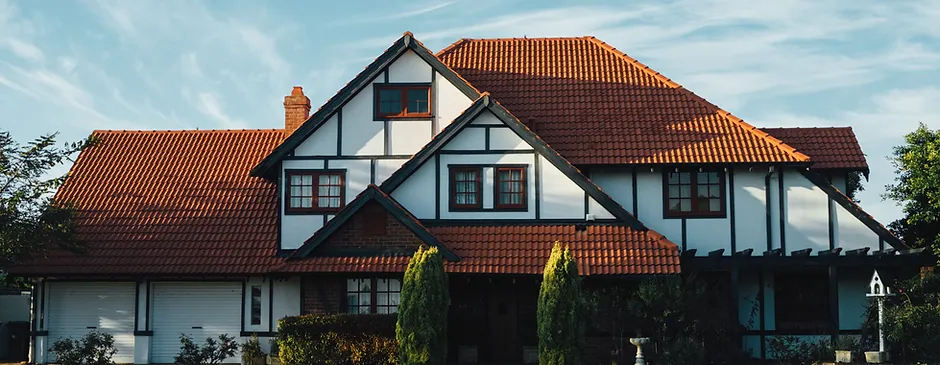 A large white and black house with a red tile roof.