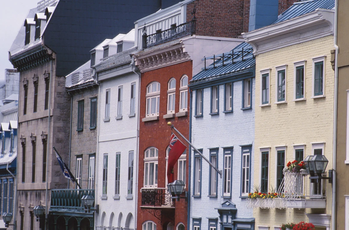 A row of buildings with a red flag in the middle