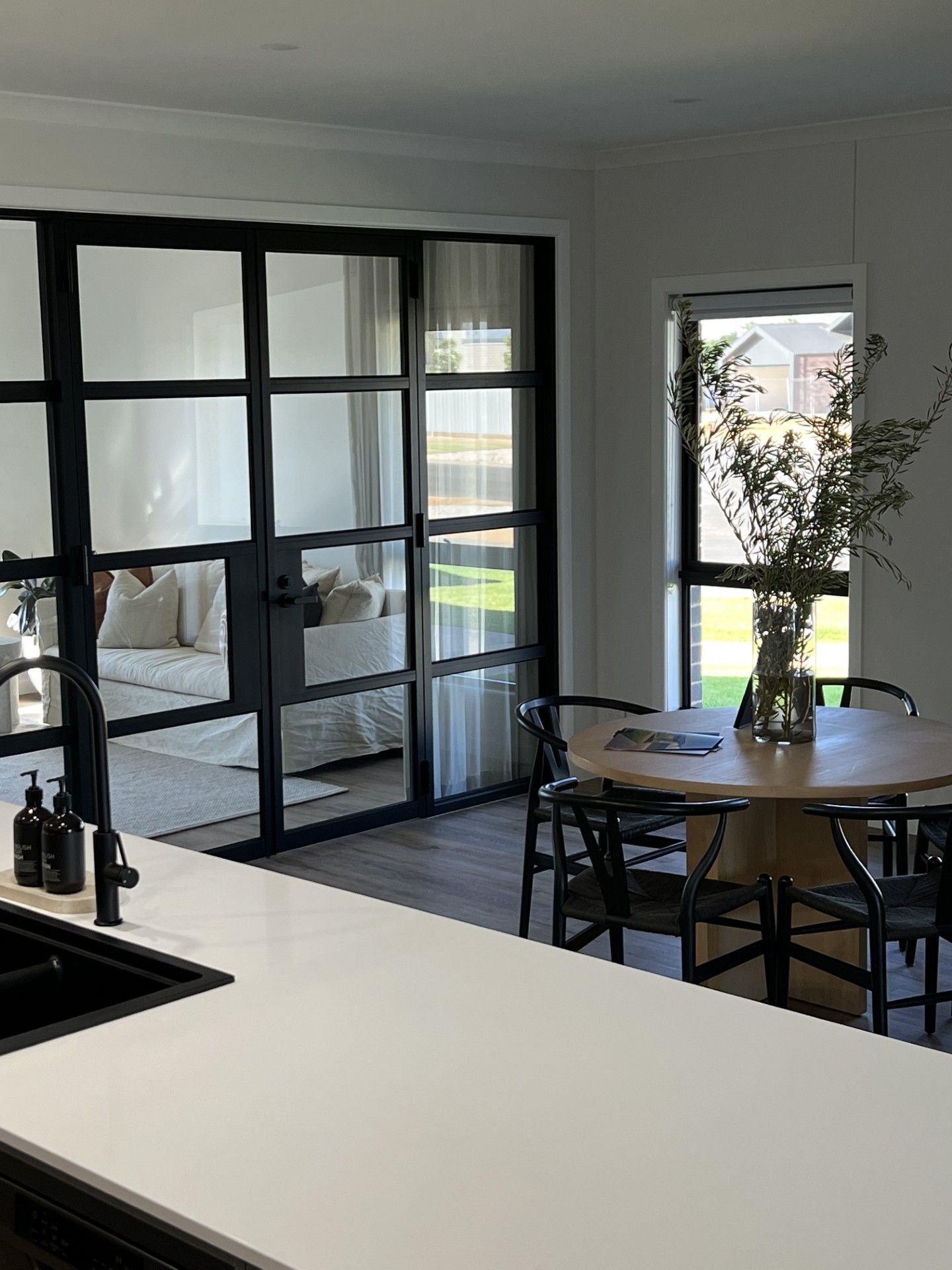 A modern office kitchen with dark brown cabinets, stainless steel appliances, and a white countertop.