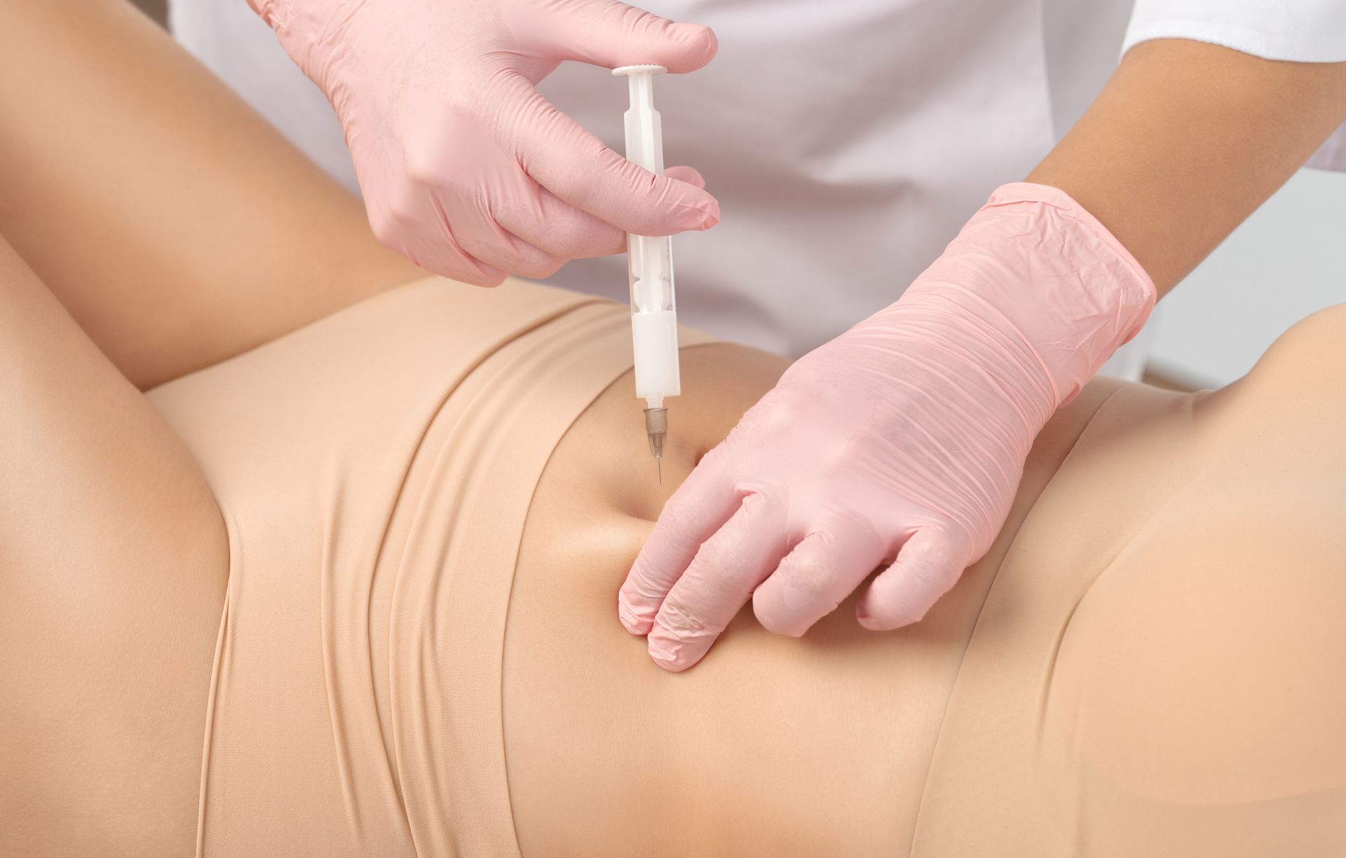 A woman is getting an injection in her stomach.