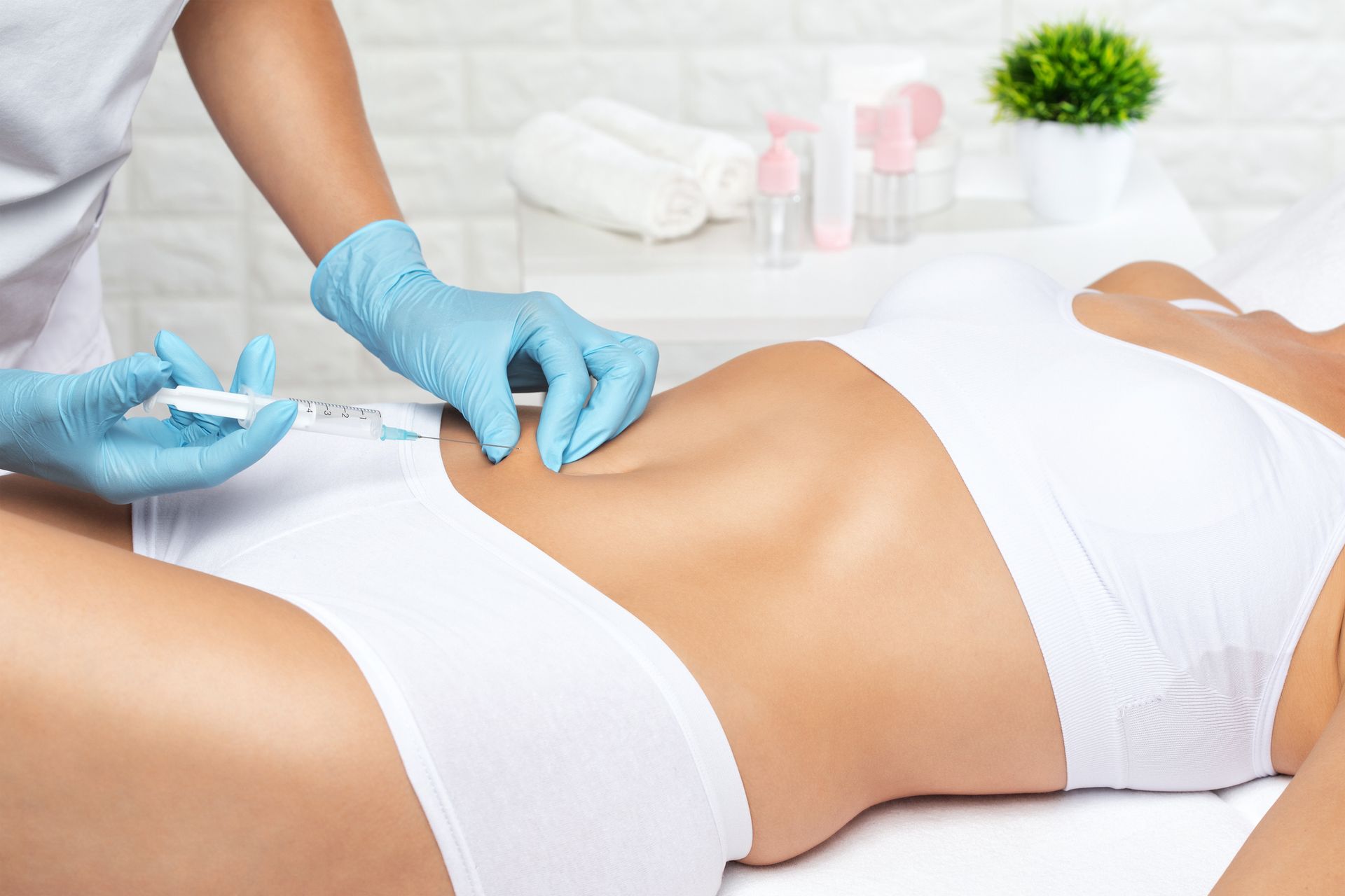 A woman is getting an injection in her stomach.