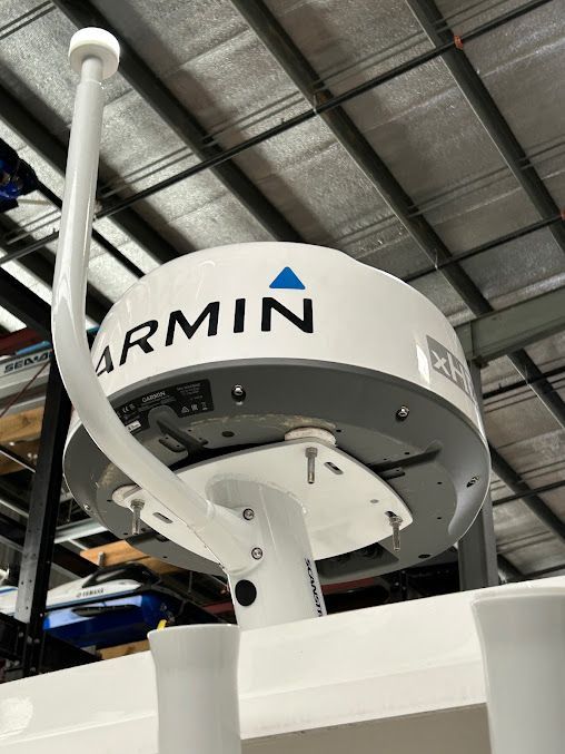 A garmin radar is sitting on top of a boat in a warehouse.