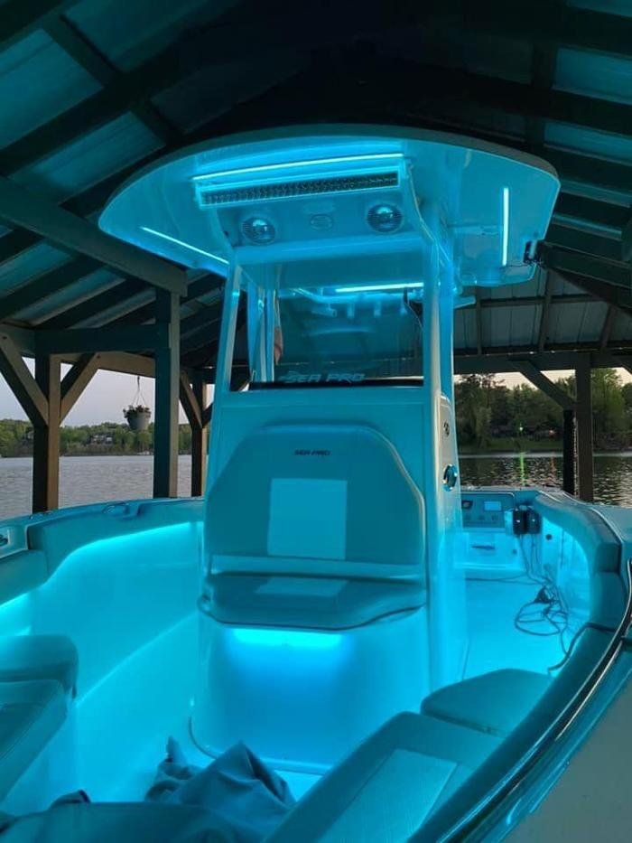 A boat is lit up with blue lights in a dock.