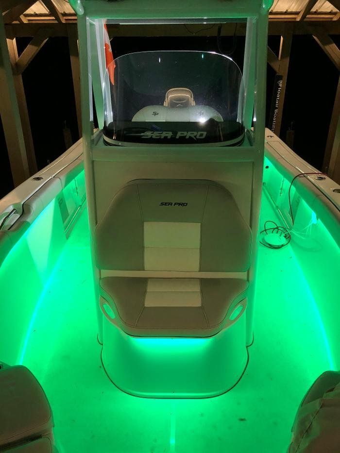 The inside of a boat with green lights on it.