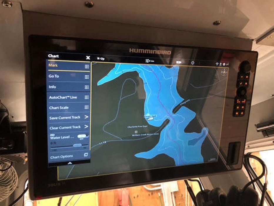 A large monitor is hanging from the ceiling of a boat.