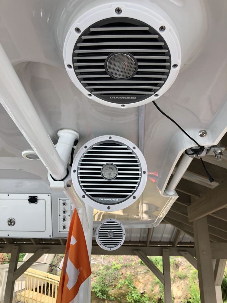 Two speakers are mounted to the ceiling of a boat.