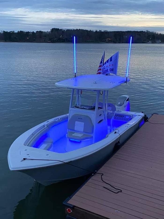 A boat is docked at a dock with blue lights on it.