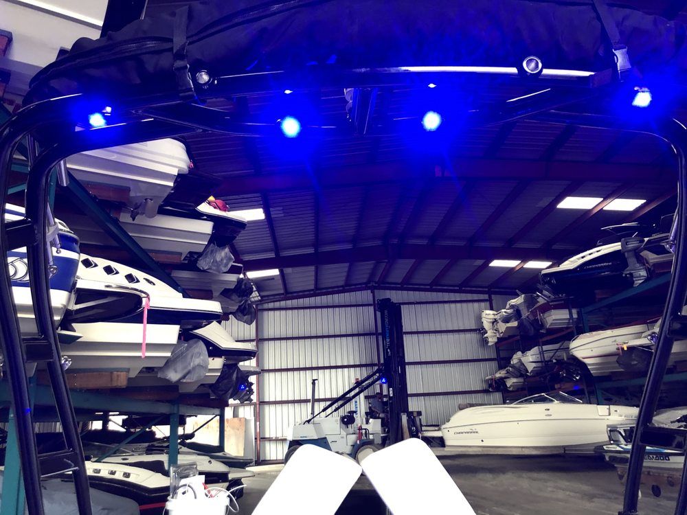 A warehouse full of boats with blue lights on the ceiling