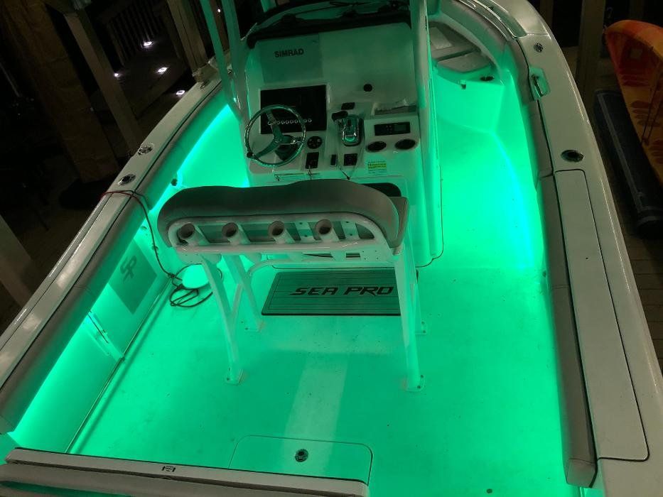 The inside of a boat is lit up with green lights.