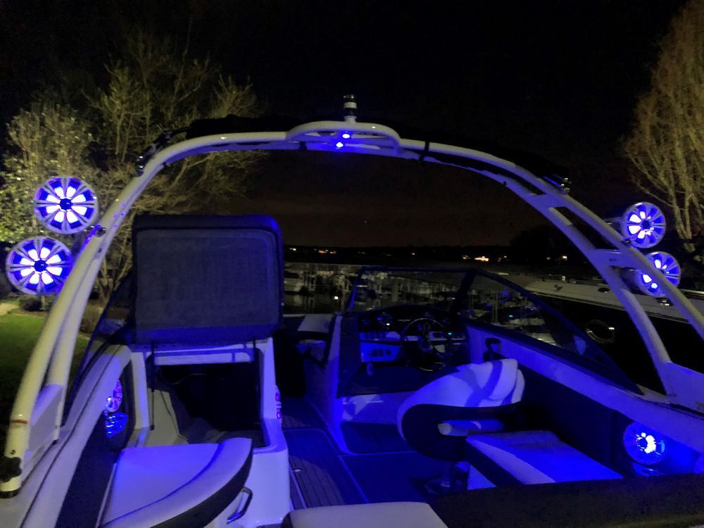 A boat is lit up with blue lights at night