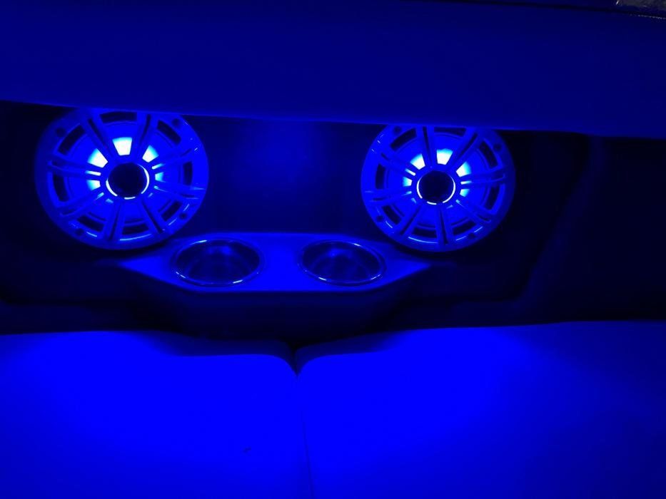 A pair of speakers are sitting under a blue light.