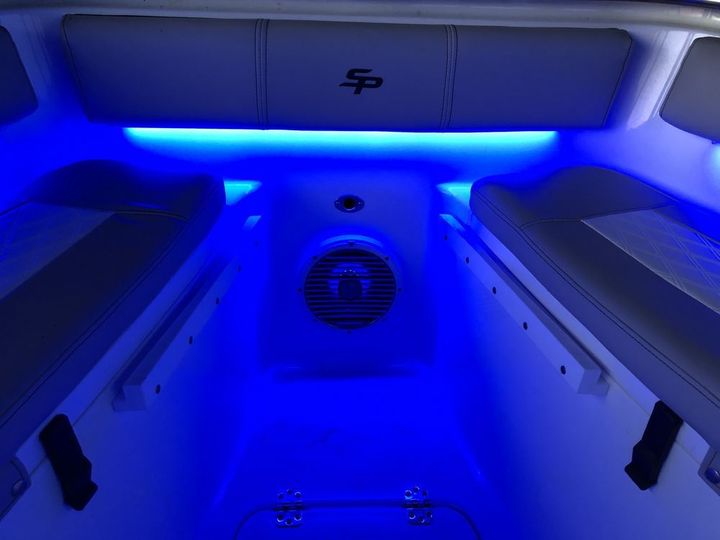 The inside of a boat with blue lights and a speaker.