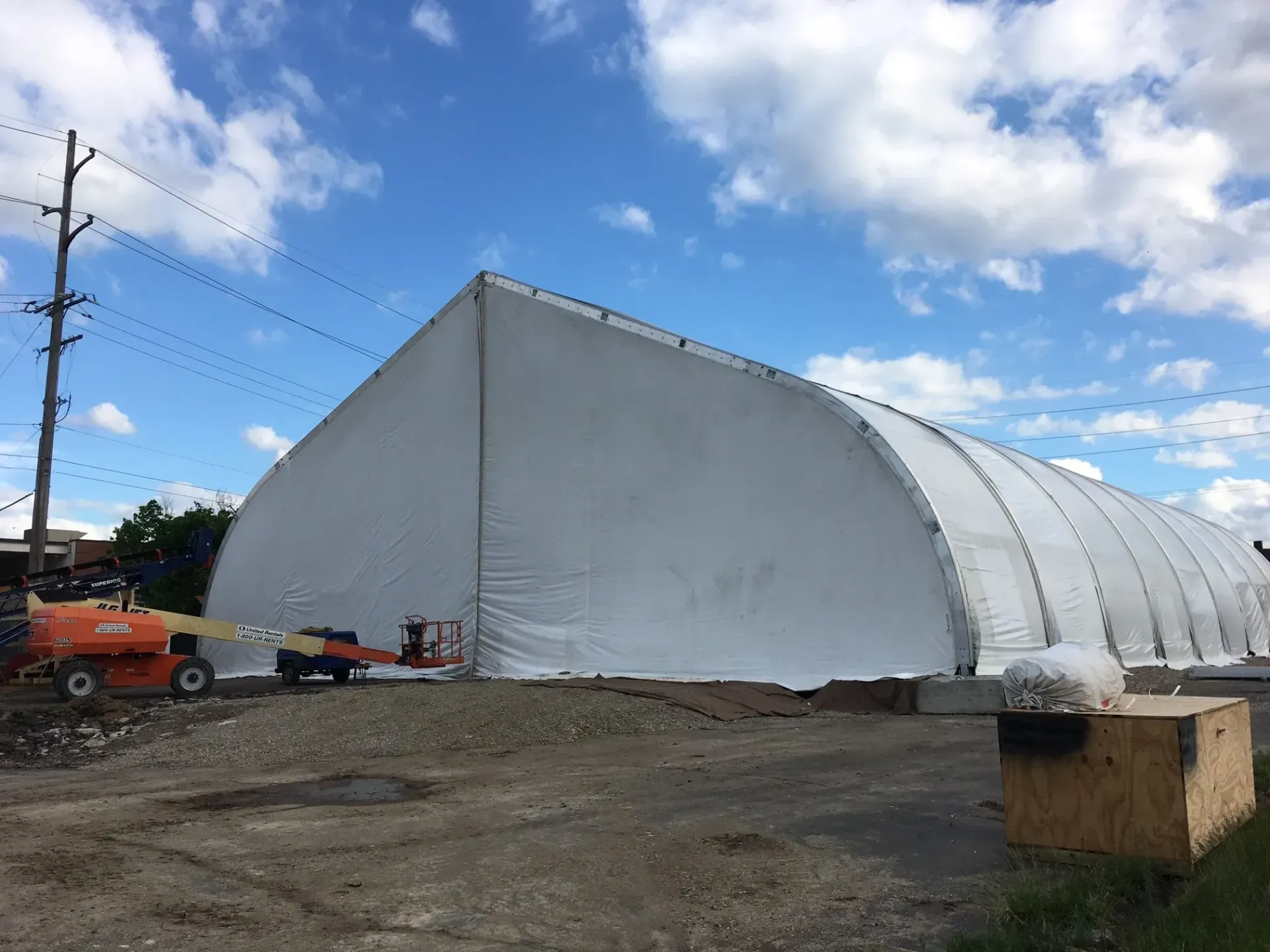 A large white tent is sitting in the middle of a dirt field.