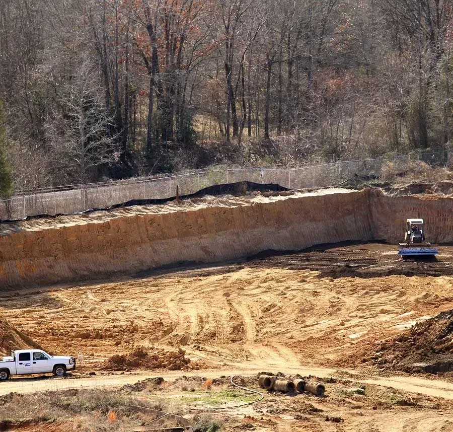A white truck is parked in the middle of a dirt field