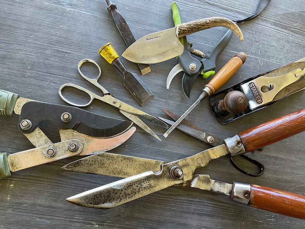A Bunch of Gardening Tools Are Laying on a Wooden Table — Shaving Sharp Knives And Tools in Centenary Heights, QLD