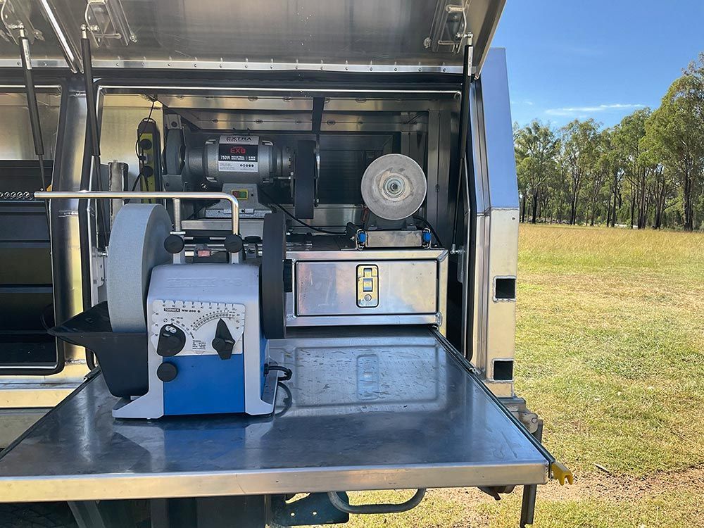 A Machine is Sitting on Top of a Stainless Steel Table in the Back of a Truck — Shaving Sharp Knives And Tools in Centenary Heights, QLD