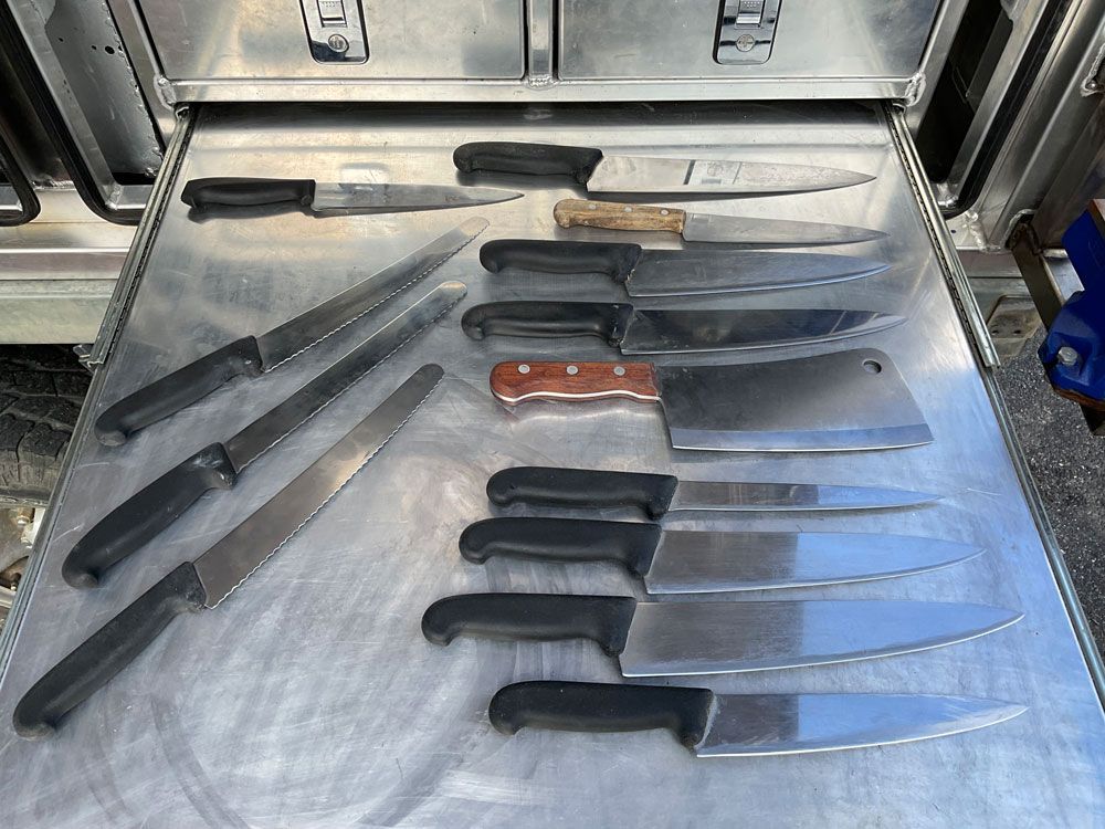 A Bunch of Knives Are Lined Up on a Table — Shaving Sharp Knives And Tools in Centenary Heights, QLD