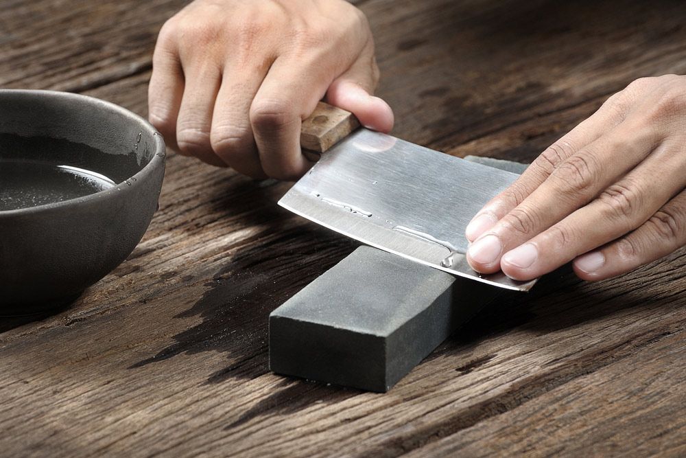A Man Sharpening a Butcher Knife — Shaving Sharp Knives And Tools in Toowoomba, QLD