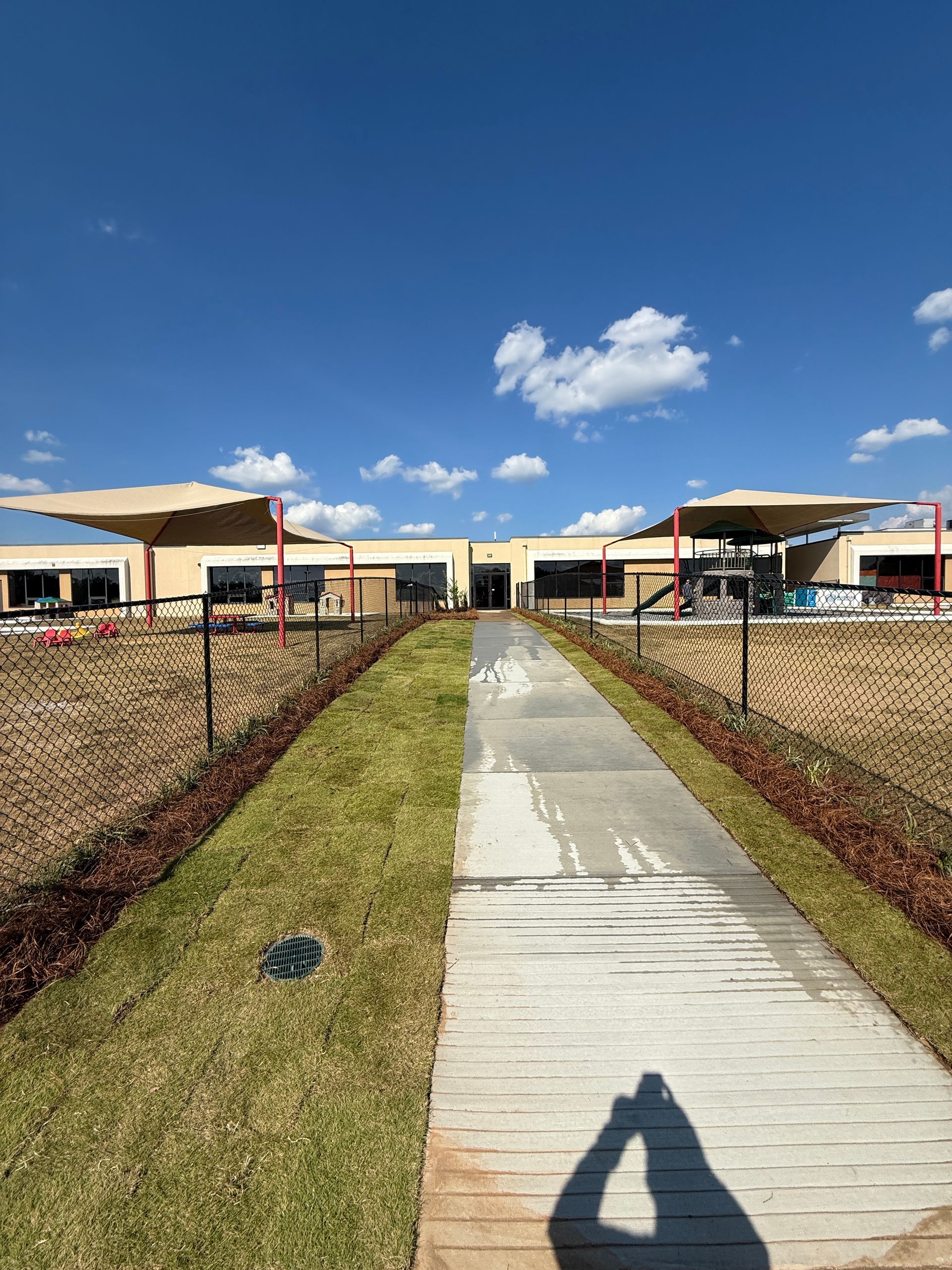 A sunny day view of a building with shade structures. 